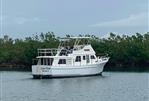 Monk 38 - 1978 Monk 38 boat named "Carpe Diem" on calm water near lush greenery.