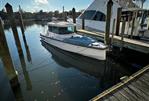 Axopar 28 CABIN - 2023 Axopar 28 CABIN boat docked in a marina under clear skies.