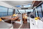 Jeanneau Merry Fisher 1095 - Jeanneau Merry Fisher 1095 - wheelhouse interior with port side saloon seating, starboard side galley and forward pilot + co-pilot seats