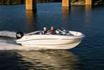 Bayliner VR5 - 2024 Bayliner VR5 boat cruising on a serene lake under a bridge.