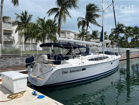 Hunter 50ac - 2010 Hunter 50ac sailboat docked at marina with palm trees and buildings in background.