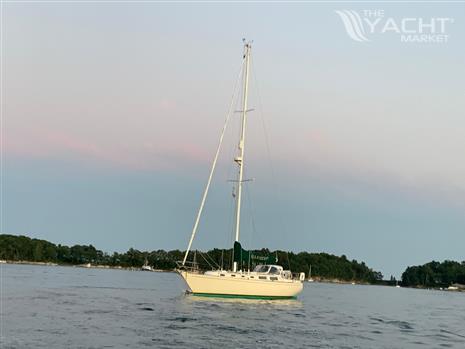 Sabre 38 - 1982 Sabre 38 sailboat anchored on calm water at sunset.