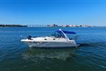 Sea Ray 340 Sundancer - 2002 Sea Ray 340 Sundancer cruising on a sunny day with cityscape in background.