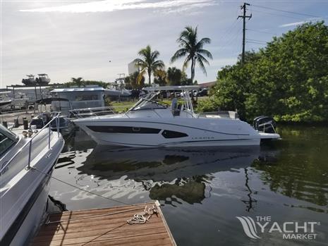 Jeanneau Leader 10.5 - 2018 Jeanneau Leader 10.5 boat docked in a marina with palm trees.