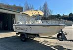 Robalo 1820 Center Console - 1994 Robalo 1820 Center Console boat on trailer, parked outside storage units.