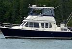 Sabreline 36 Aft Cabin Trawler - 1995 Sabreline 36 Aft Cabin Trawler on calm water, forested background.