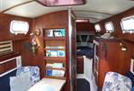 Endeavour 32 - 1979 Endeavour 32 sailboat interior with wooden cabinetry, seating area, and bookshelf.
