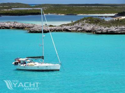 Beneteau 393 - 2003 Beneteau 393 sailboat anchored in clear turquoise waters near rocky shoreline.