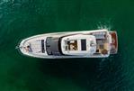 Prestige 690 - Aerial view of 2025 Prestige 690 yacht cruising on clear green water.