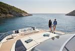 Prestige M8 - Couple enjoying the deck of a 2025 Prestige M8 yacht in a scenic bay.