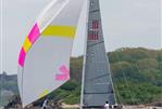 Custom Hallett 33 - Sailing a 2007 Custom Hallett 33 boat with colorful spinnaker on a calm sea.