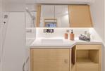 Hanse 410 - Modern bathroom in 2024 Hanse 410 yacht with wooden cabinetry and sleek fixtures.