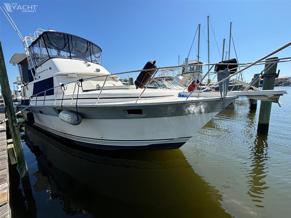 Silverton AFT CABIN - 1987 Silverton AFT CABIN yacht docked in marina under clear blue sky.