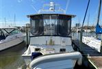 Silverton AFT CABIN - 1987 Silverton AFT CABIN boat docked at marina under clear blue sky.