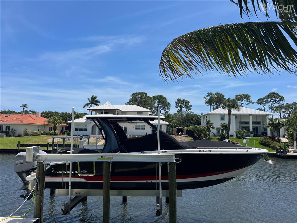 Chaparral 300 OSX - 2019 Chaparral 300 OSX boat docked in a scenic waterfront neighborhood.