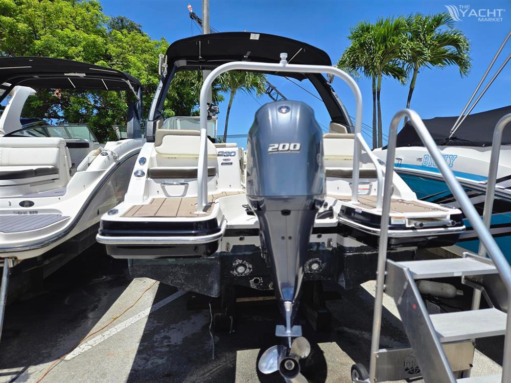 Chaparral 230 - 2021 Chaparral 230 boat with 200 HP outboard motor, docked under clear blue sky.