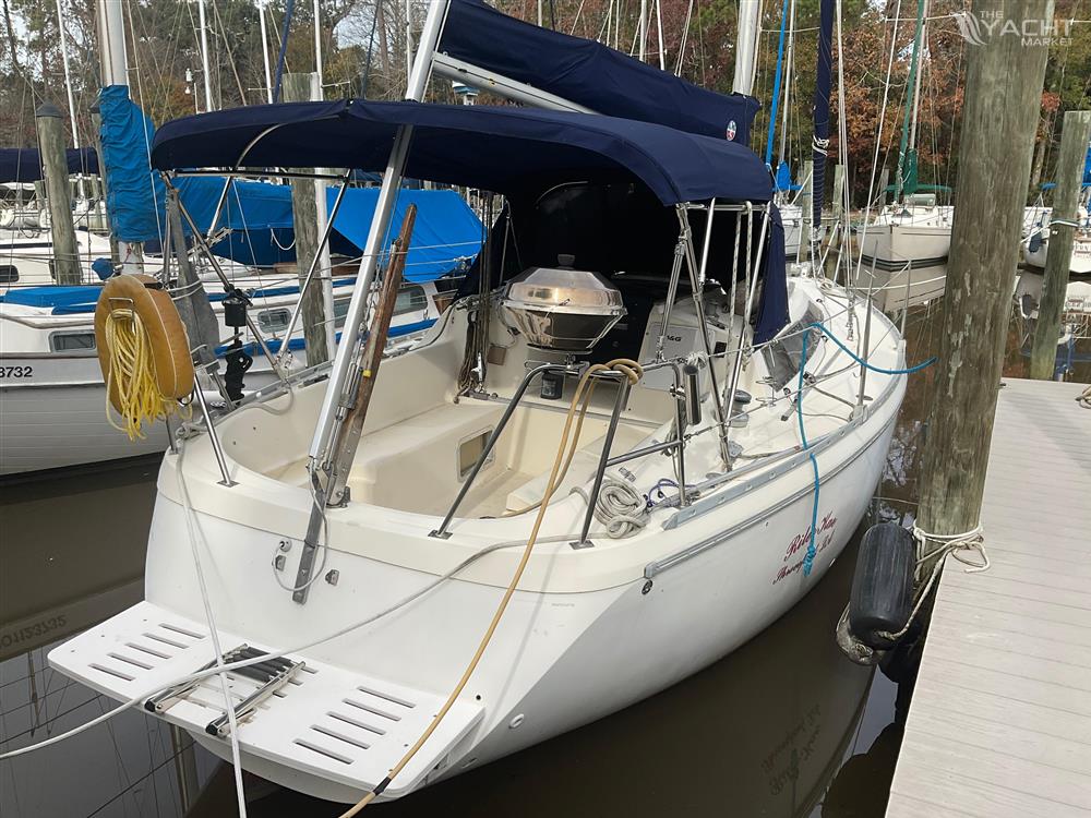 Jeanneau Attalia - 1983 Jeanneau Attalia sailboat docked, featuring a blue canopy and white hull.