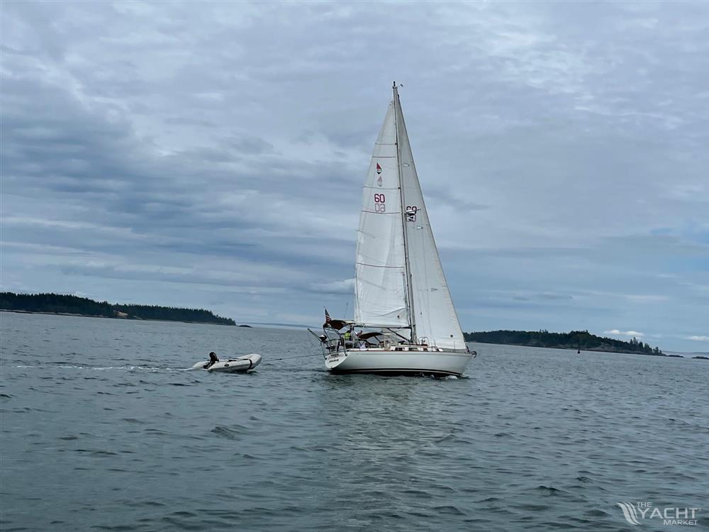 Bristol 35.5 - 1980 Bristol 35.5 sailboat on calm waters with a small dinghy nearby.