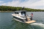 Targa 32 - Targa 32 boat cruising on a lake, 2025 model, with American flag, forested shoreline.
