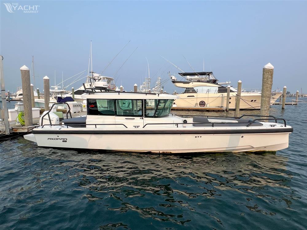 Axopar 28 CABIN - 2020 Axopar 28 CABIN boat docked in a marina, surrounded by other vessels.
