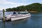 Axopar 28 CABIN - 2020 Axopar 28 CABIN boat docked on a serene lake with forested background.