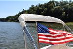 MJM 36z Downeast - MJM 36z Downeast 2013 boat with American flag on a serene lake.