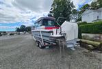 Axopar 28 - 2022 Axopar 28 boat on trailer, parked outdoors with cloudy sky.