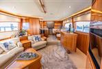 Bertram 670E - Luxurious interior of 2004 Bertram 670E yacht with elegant wood finishes and plush seating.