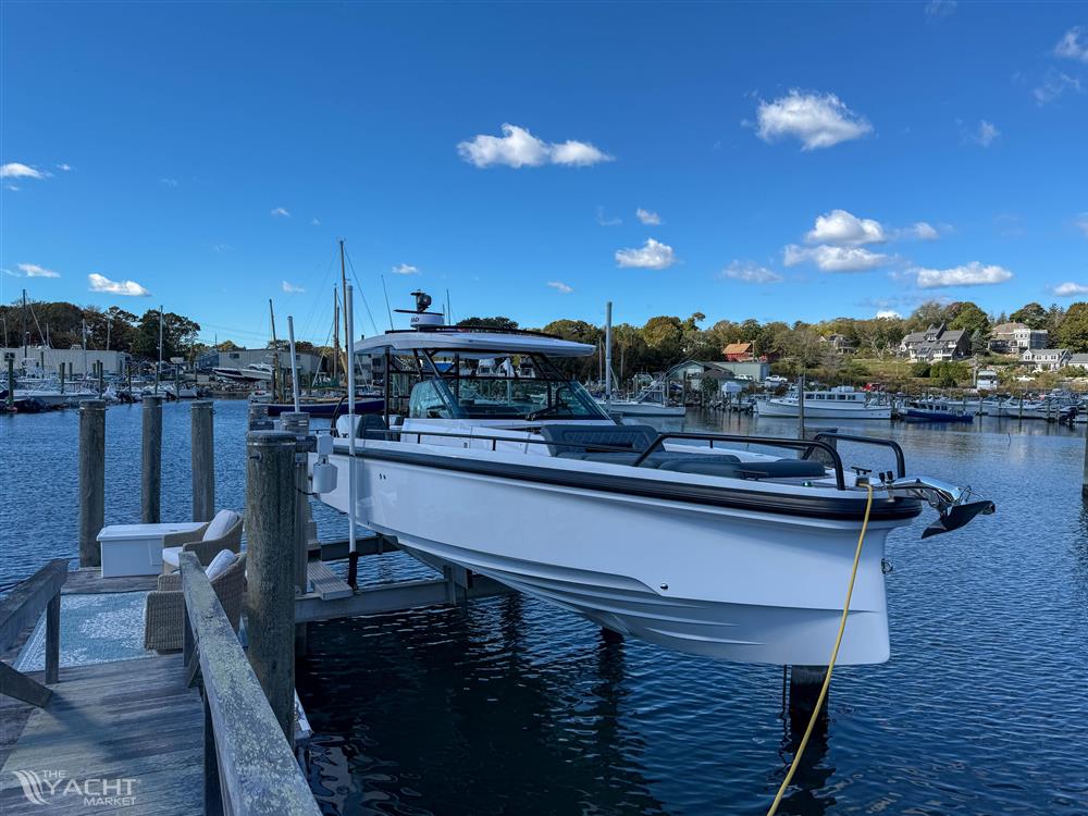 Axopar 37 Sun Top - 2022 Axopar 37 Sun Top boat docked at a marina under a clear blue sky.
