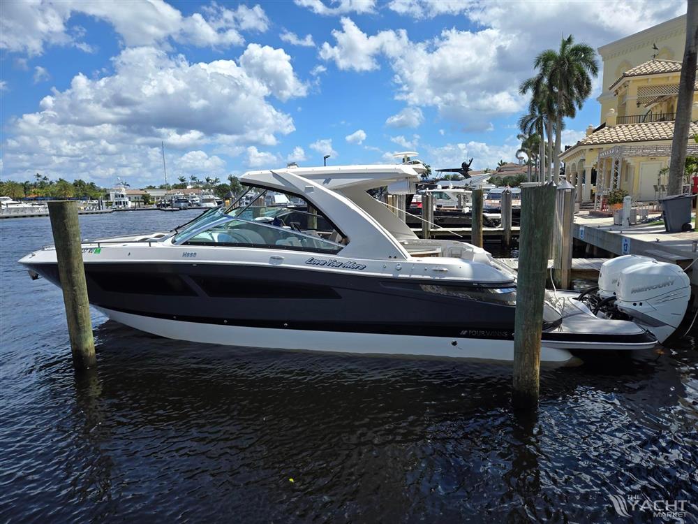 Four Winns H350 - 2019 Four Winns H350 boat docked on a sunny day, with palm trees and blue sky.