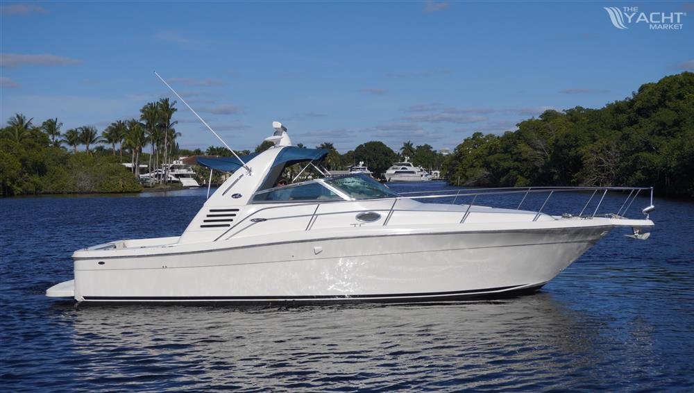 Sea Ray 340 Amberjack - 2002 Sea Ray 340 Amberjack boat on a calm river with lush greenery.