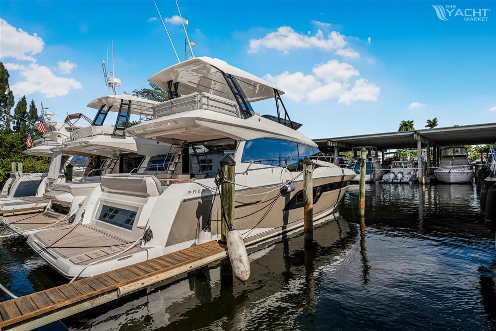 Prestige 520 - 2024 Prestige 520 yacht docked at marina under clear blue sky.