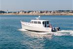 Wesmac 42 - 2016 Wesmac 42 boat cruising near a coastal town with a lighthouse.