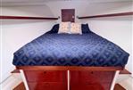 Wesmac 42 - Cozy cabin interior of 2016 Wesmac 42 with blue bedding and wooden drawers.