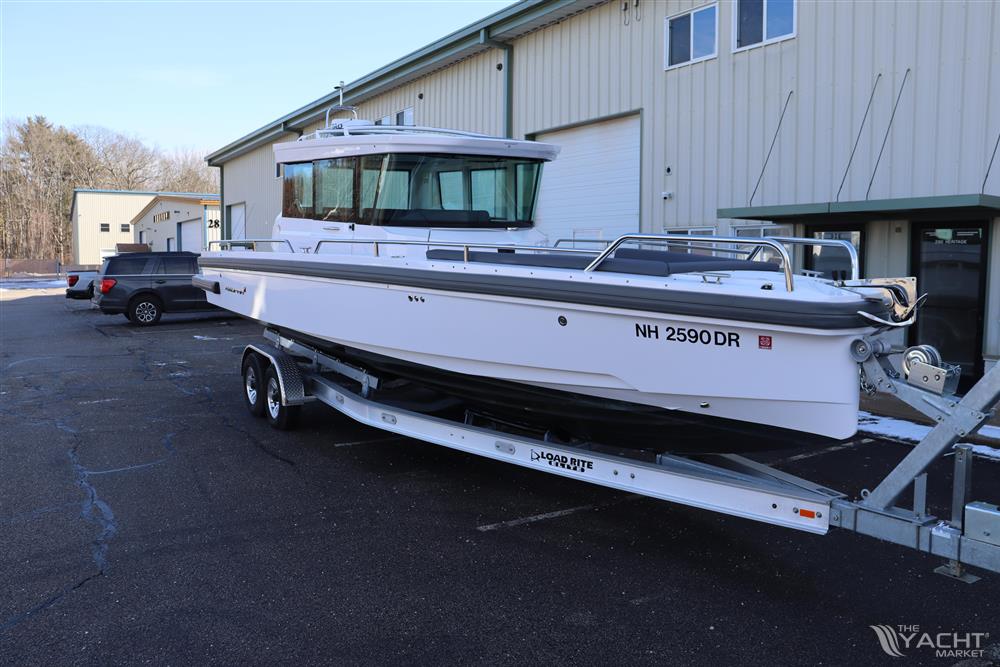 Axopar 28 CABIN - 2021 Axopar 28 CABIN boat on trailer outside a warehouse.