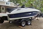 Sea Ray 220 Sundeck - 2015 Sea Ray 220 Sundeck boat on trailer, parked in a gravel driveway.