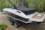 Sea Ray 220 Sundeck - 2015 Sea Ray 220 Sundeck boat on trailer, covered, in a wooded area.