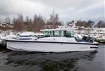 Axopar 29 Cross Cabin - 2025 Axopar 29 Cross Cabin boat on a snowy shoreline, sleek design, winter setting.