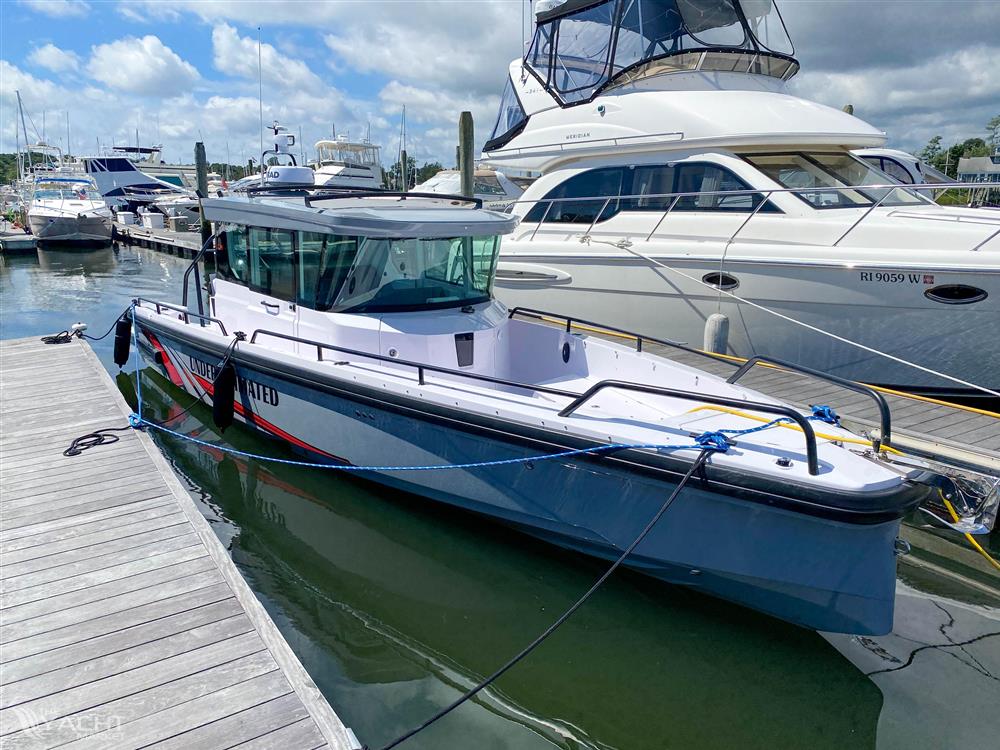 Axopar 28 CABIN - 2021 Axopar 28 CABIN boat docked at a marina under a partly cloudy sky.