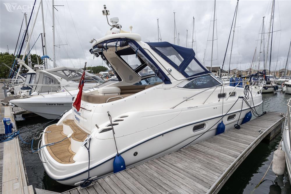 Sealine S34 - 2004 Sealine S34 yacht docked at marina, featuring sleek design and blue canopy.