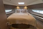 Princess V50 Open - Luxurious bedroom interior of 2023 Princess V50 Open yacht with elegant bedding and wood accents.