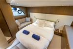 Princess V48 Open - Luxurious bedroom interior of 2017 Princess V48 Open yacht with cozy bed and seating area.