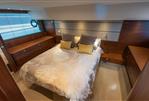 Princess 60 - Luxurious bedroom interior on a 2015 Princess 60 yacht, featuring elegant bedding and wood accents.