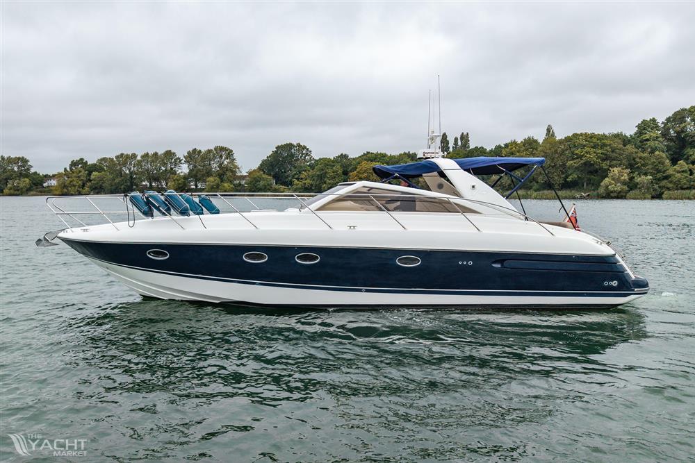 Princess V42 - 2000 Princess V42 yacht cruising on a calm lake with lush green shoreline.