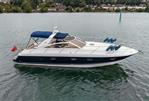 Princess V42 - 2000 Princess V42 yacht on calm water, featuring sleek design and blue canopy.