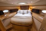 Princess V58 - Luxurious cabin interior of 2009 Princess V58 yacht with cozy bed and porthole windows.