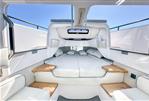 Axopar 37 Sun Top - Luxurious interior of 2024 Axopar 37 SunTop boat with comfortable bedding and wooden accents.