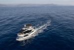 Galeon 430 Explorer - 2025 Galeon 430 Explorer yacht cruising on open sea with distant coastline.