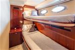 Princess V58 - Interior of 2005 Princess V58 yacht with cozy twin bunk beds and wooden cabinetry.