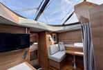 Sealine F46 - Interior of 2011 Sealine F46 yacht with skylight, TV, and seating area.